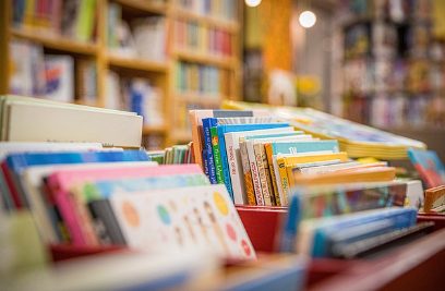 Imagem de uma biblioteca com perspectiva de livros e ao fundo estantes com livros